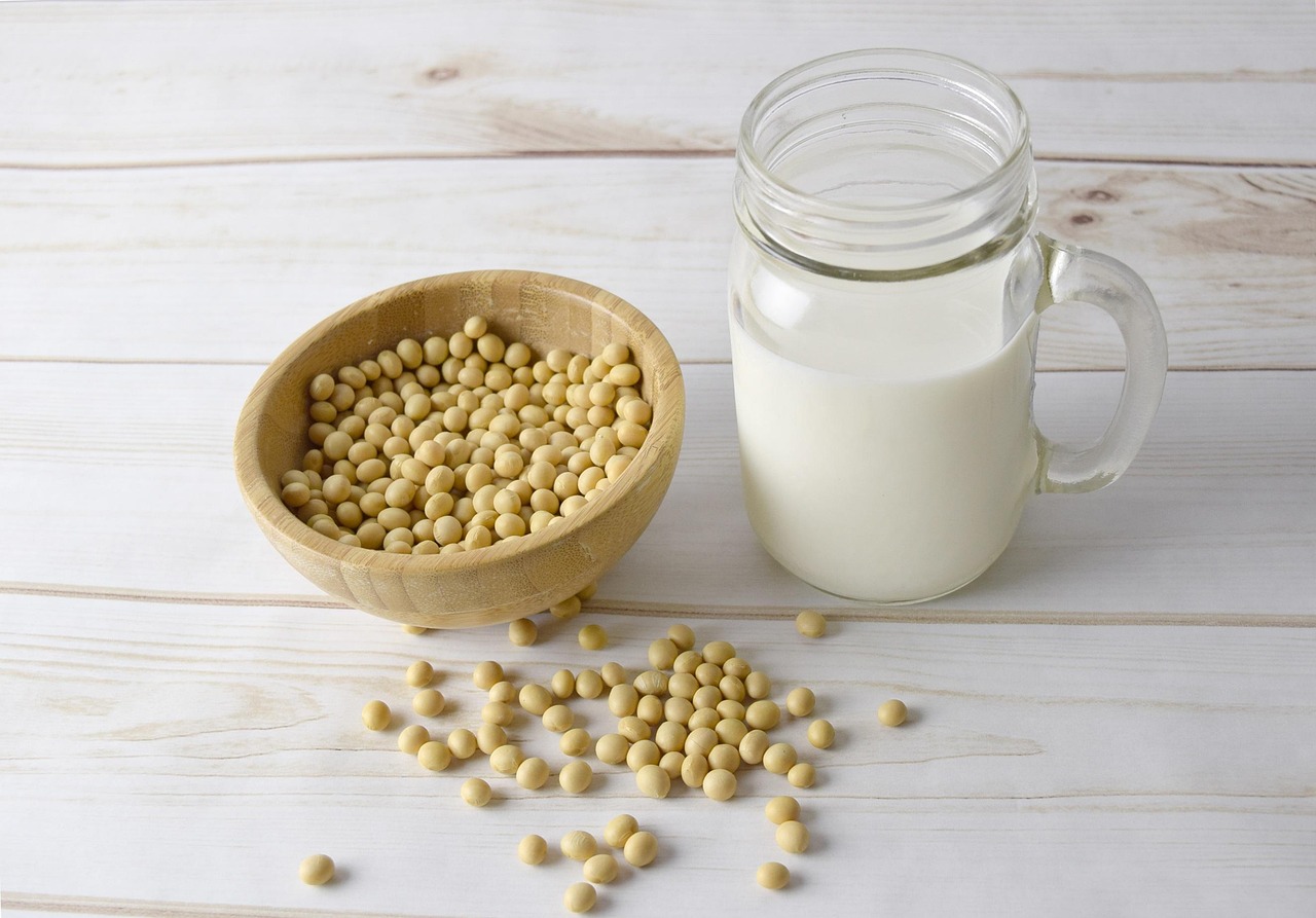 Soy beans in a bowl and soy milk in a jar.